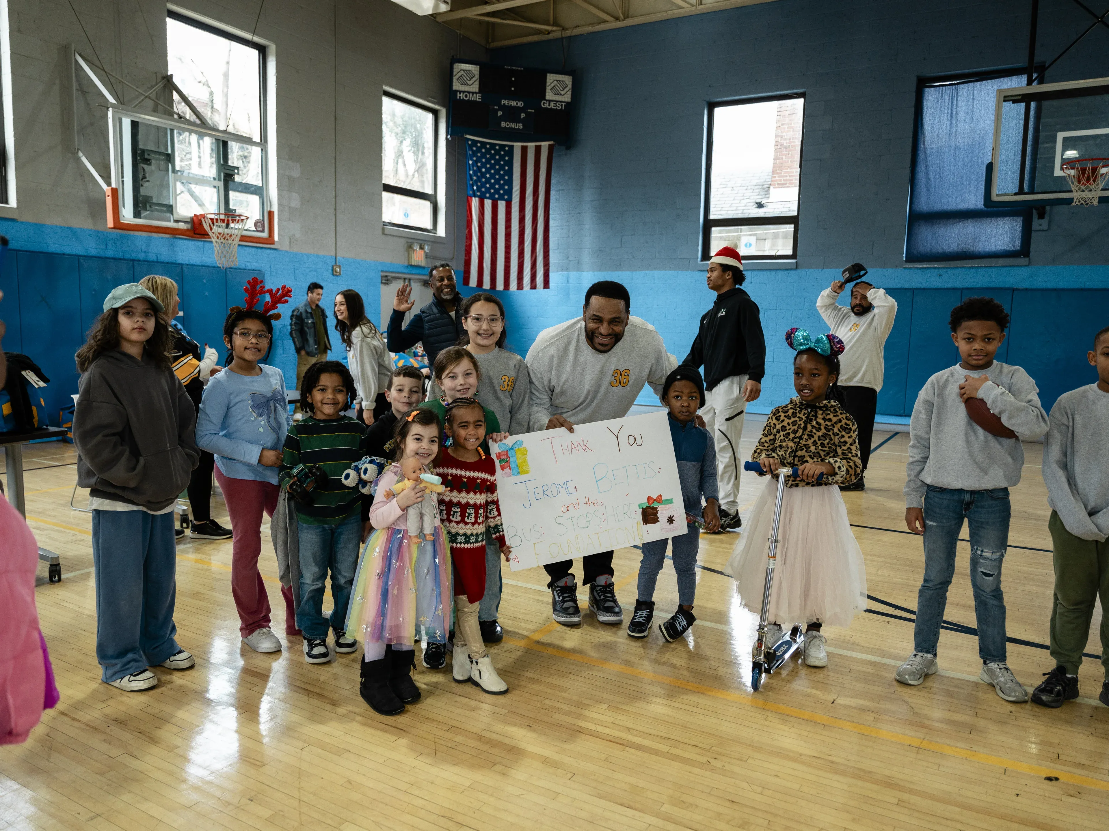 Jerome Bettis with children holding a thank-you sign at the foundation's Annual Toy Drive